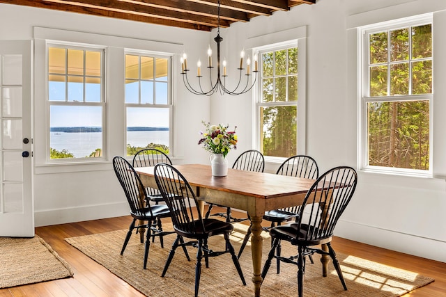 286 Atlantic Hwy, Northport, ME 04849 - dining room with wood finished floors, beam ceiling, a chandelier, a water view, and baseboards