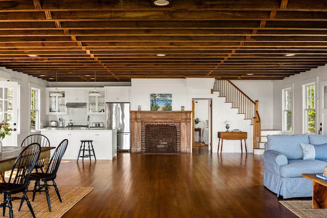 286 Atlantic Hwy, Northport, ME 04849 - living room with stairs, dark wood-style flooring, and a brick fireplace