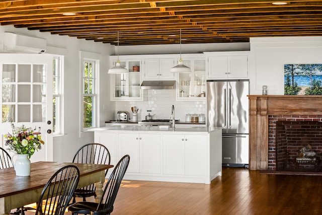 286 Atlantic Hwy, Northport, ME 04849 - kitchen with high quality fridge, a wall mounted air conditioner, a center island with sink, a sink, and under cabinet range hood