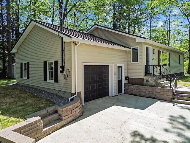 7 Philip Ave, Augusta, ME 04330 - view of front facade featuring an attached garage, a standing seam roof, metal roof, and concrete driveway