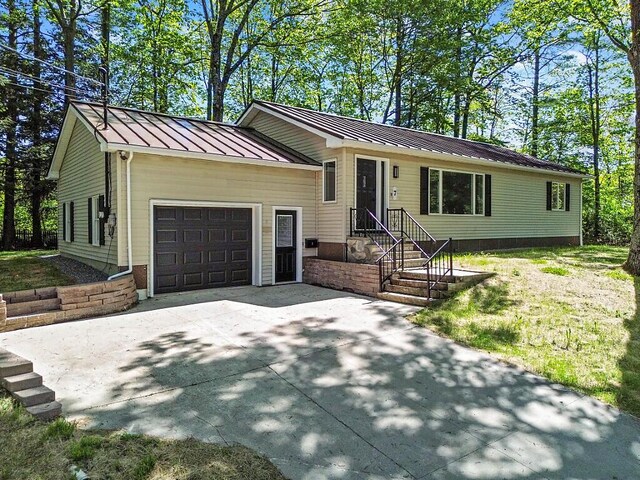 7 Philip Ave, Augusta, ME 04330 - view of front of house with an attached garage, a standing seam roof, driveway, and metal roof
