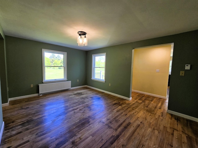237 Bangor Rd, Unity, ME 04988 - empty room featuring radiator heating unit, plenty of natural light, dark wood-style flooring, and baseboards