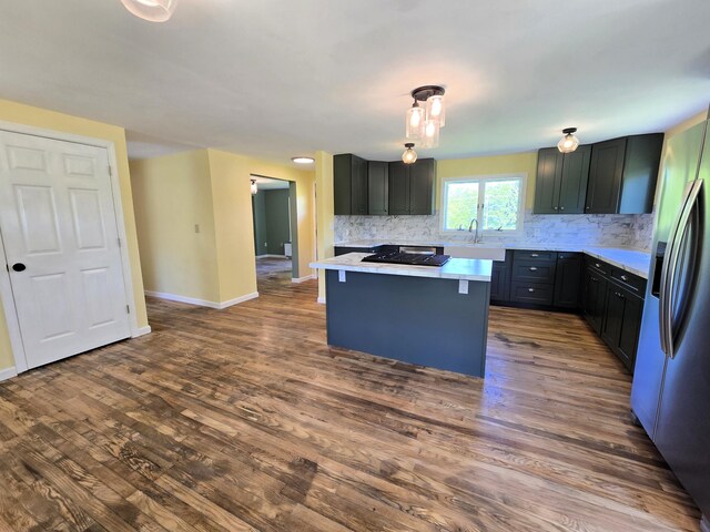 237 Bangor Rd, Unity, ME 04988 - kitchen with stainless steel fridge with ice dispenser, a sink, stovetop, light countertops, and tasteful backsplash