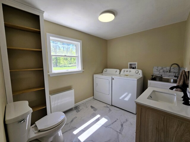 237 Bangor Rd, Unity, ME 04988 - laundry area featuring radiator heating unit, washing machine and dryer, and light marble finish flooring