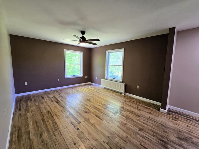 237 Bangor Rd, Unity, ME 04988 - empty room featuring radiator, wood finished floors, a ceiling fan, and baseboards