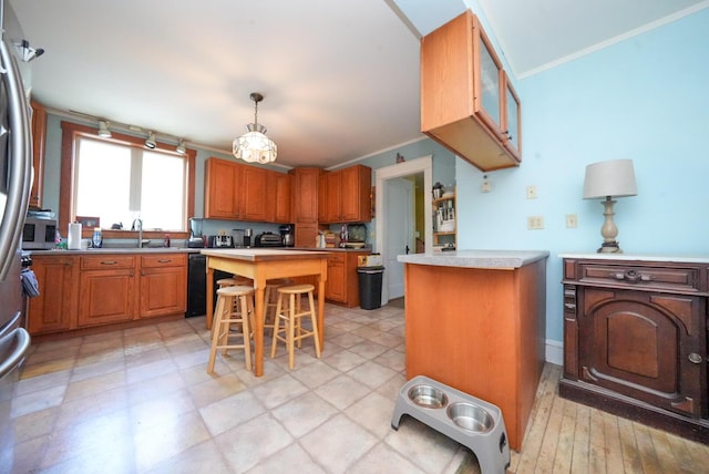 55 Poplar St, Bangor, ME 04401 - kitchen with a sink, dishwasher, brown cabinets, crown molding, and a breakfast bar