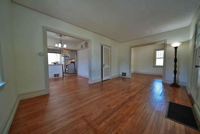 6 Pleasant Ct, Houlton, ME 04730 - spare room featuring hardwood / wood-style flooring, a chandelier, and baseboards