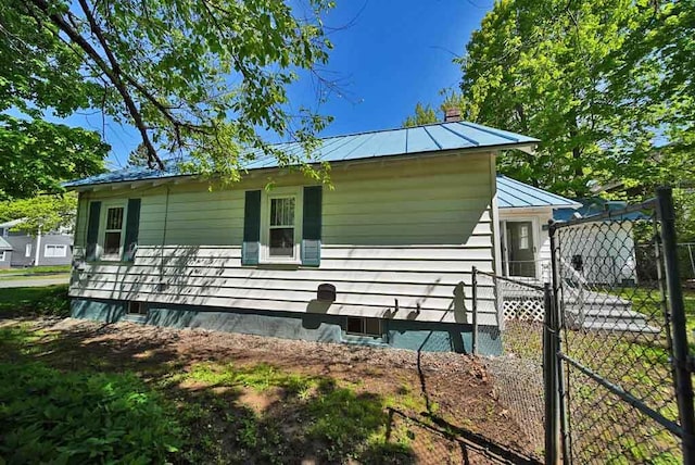 6 Pleasant Ct, Houlton, ME 04730 - view of side of property featuring a standing seam roof, metal roof, a gate, and a chimney