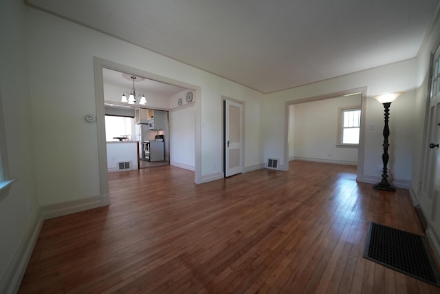 6 Pleasant Ct, Houlton, ME 04730 - unfurnished living room with a chandelier, wood-type flooring, and baseboards
