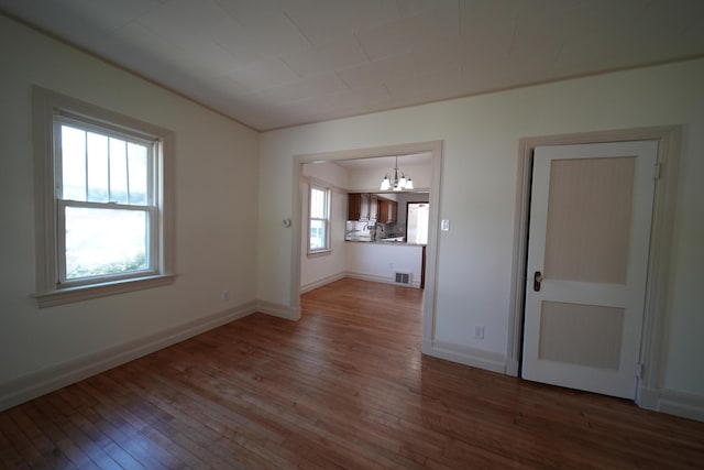 6 Pleasant Ct, Houlton, ME 04730 - unfurnished living room with a chandelier, wood-type flooring, and baseboards