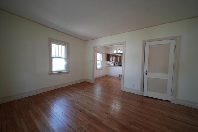 6 Pleasant Ct, Houlton, ME 04730 - empty room with wood-type flooring, a chandelier, a sink, and baseboards