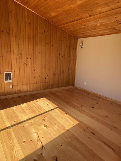 20 Monument Rd, Abbot, ME 04406 - empty room featuring wood-type flooring, wood ceiling, and wood walls