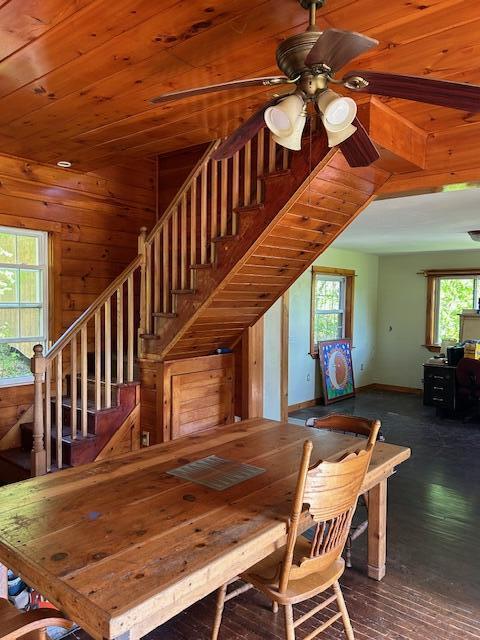 20 Monument Rd, Abbot, ME 04406 - dining space with stairs, ceiling fan, wooden walls, hardwood / wood-style flooring, and baseboards