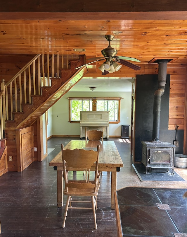 20 Monument Rd, Abbot, ME 04406 - dining space featuring stairs, ceiling fan, a wood stove, and baseboards