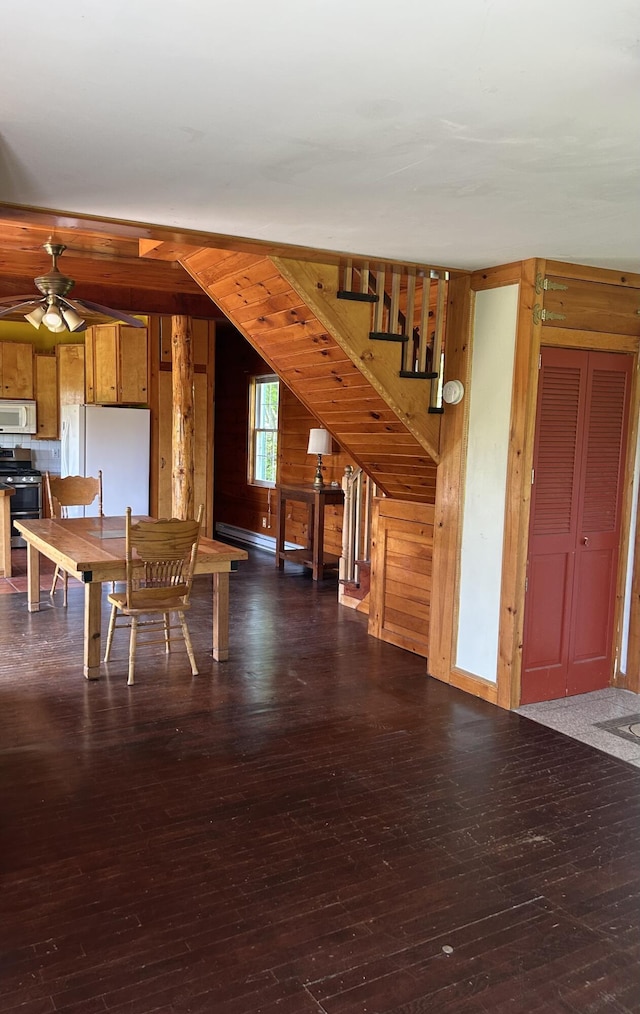 20 Monument Rd, Abbot, ME 04406 - dining room featuring wooden walls, a baseboard radiator, ceiling fan, and hardwood / wood-style flooring