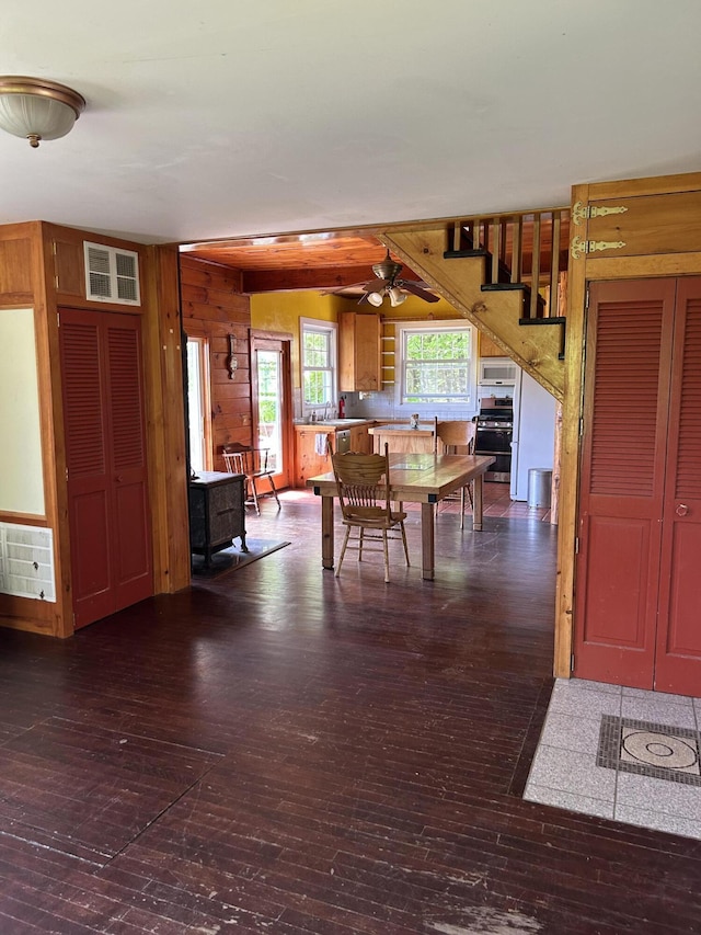20 Monument Rd, Abbot, ME 04406 - dining area with wood-type flooring, a ceiling fan, wooden walls, and stairs
