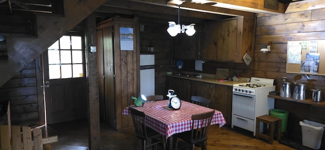 1261 Turkey Tail Rd Unit T4, Indian Purchase Twp, ME 04462 - kitchen with white gas stove, dark wood-style floors, fridge, wooden walls, and light countertops