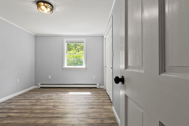 30 Ring Landing Rd, Casco, ME 04015 - empty room featuring a baseboard heating unit, baseboards, crown molding, and wood finished floors