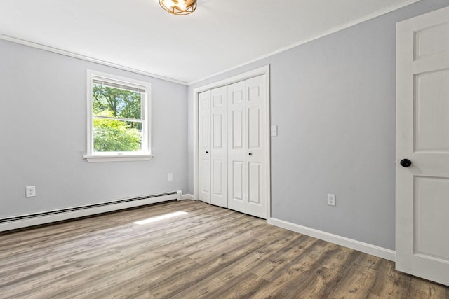 30 Ring Landing Rd, Casco, ME 04015 - unfurnished bedroom featuring wood finished floors, a closet, baseboards, ornamental molding, and a baseboard heating unit
