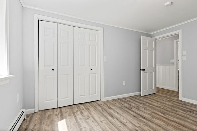 30 Ring Landing Rd, Casco, ME 04015 - unfurnished bedroom with a baseboard radiator, ornamental molding, light wood-style floors, a closet, and baseboards