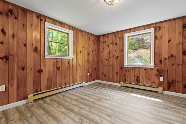 30 Ring Landing Rd, Casco, ME 04015 - unfurnished room featuring a baseboard heating unit, plenty of natural light, wood finished floors, and wooden walls