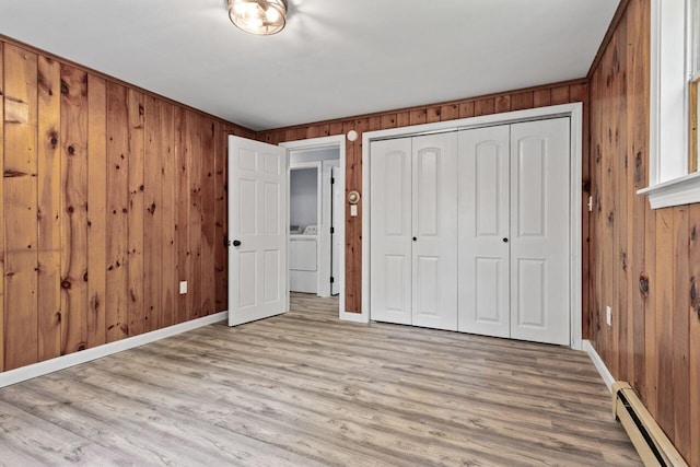 30 Ring Landing Rd, Casco, ME 04015 - unfurnished bedroom featuring baseboard heating, baseboards, wood walls, a closet, and washing machine and dryer