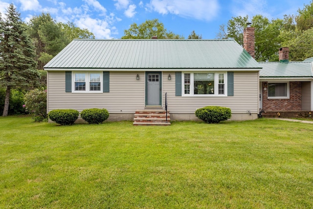 18 Tibbetts Ln, Lyman, ME 04002 - view of front of house featuring a chimney, a front yard, metal roof, and entry steps