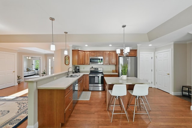 40 Camden Ct Unit 40, Bangor, ME 04401 - kitchen with appliances with stainless steel finishes, a sink, brown cabinets, a breakfast bar area, and light wood-type flooring