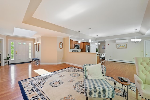 40 Camden Ct Unit 40, Bangor, ME 04401 - living room featuring a tray ceiling, a baseboard heating unit, a chandelier, a wall unit AC, and light wood finished floors