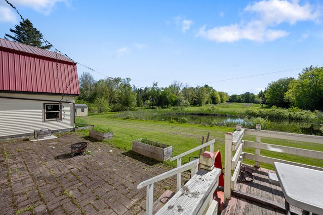87 Southard Ave, Kenduskeag, ME 04450 - view of patio / terrace with a fire pit, a water view, and an outdoor structure