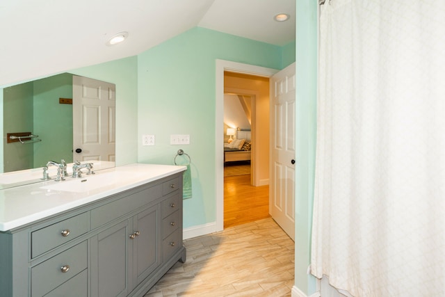10 Pemasong Ln, Yarmouth, ME 04096 - ensuite bathroom featuring vanity, wood finished floors, vaulted ceiling, and baseboards
