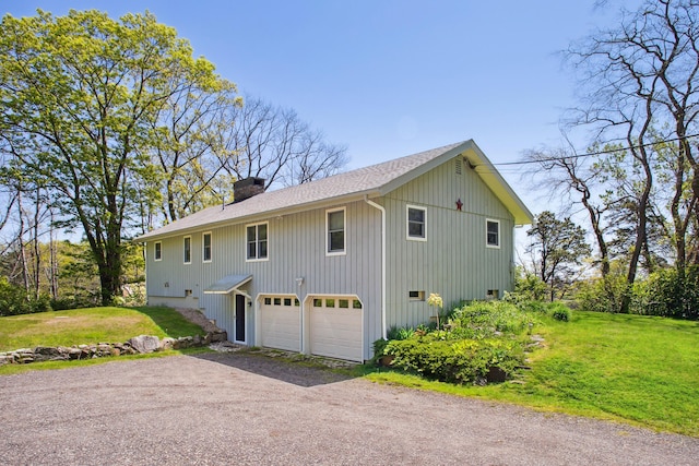142 Fortunes Rocks Rd, Biddeford, ME 04005 - view of home's exterior featuring driveway, a chimney, a yard, roof with shingles, and an attached garage