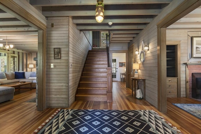 1 Mouse Is, Southport, ME 04576 - staircase with wood walls, wood finished floors, beam ceiling, healthy amount of natural light, and a chandelier