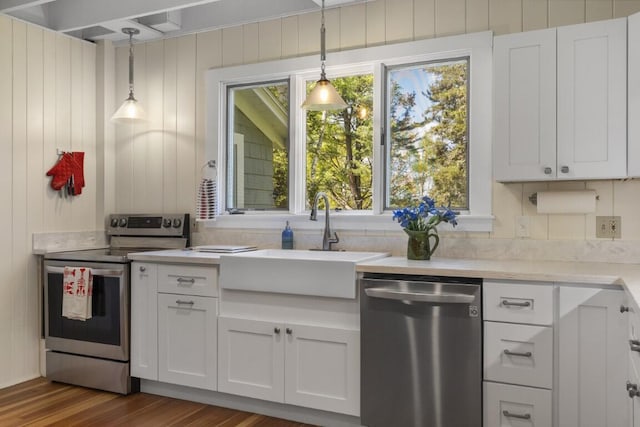 1 Mouse Is, Southport, ME 04576 - kitchen featuring appliances with stainless steel finishes, a sink, dark wood-style floors, white cabinets, and wooden walls
