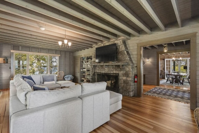 1 Mouse Is, Southport, ME 04576 - living room featuring a chandelier, wood finished floors, beam ceiling, healthy amount of natural light, and a stone fireplace