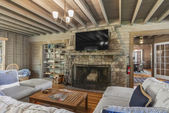 1 Mouse Is, Southport, ME 04576 - living area with wooden walls, beam ceiling, wood finished floors, and a stone fireplace