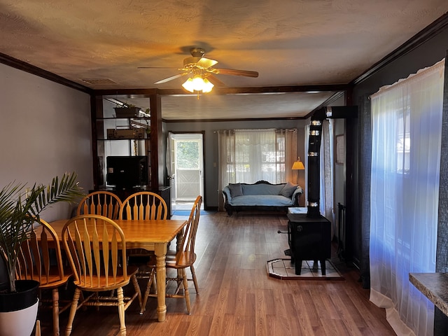 30 Highland Ave, Dixfield, ME 04224 - dining area featuring crown molding, a ceiling fan, wood finished floors, and a wood stove