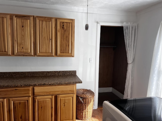 30 Highland Ave, Dixfield, ME 04224 - kitchen with brown cabinets, dark countertops, wood finished floors, and stove