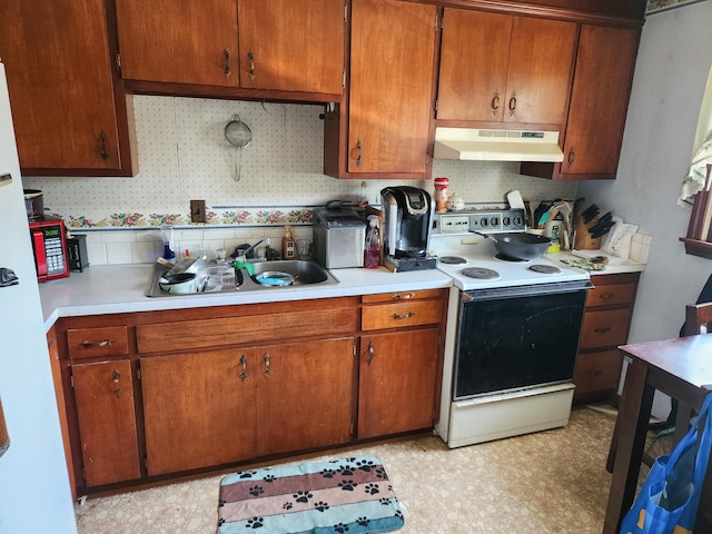65 Pearce Ave, Houlton, ME 04730 - kitchen with under cabinet range hood, electric range, a sink, light countertops, and brown cabinetry