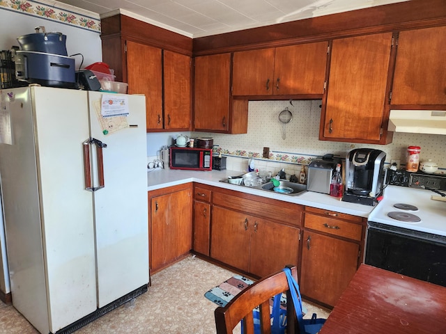 65 Pearce Ave, Houlton, ME 04730 - kitchen with freestanding refrigerator, range with electric cooktop, under cabinet range hood, a sink, and light flooring