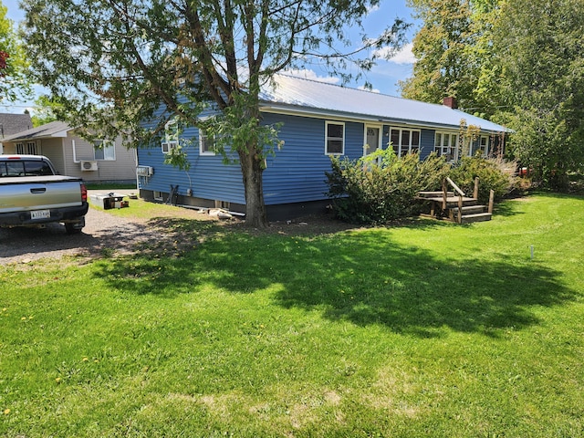 65 Pearce Ave, Houlton, ME 04730 - view of home's exterior with metal roof, a yard, and a chimney