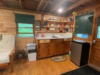 254 Eaton Rd, Dexter, ME 04435 - kitchen featuring light wood-type flooring, plenty of natural light, a sink, light countertops, and wooden walls