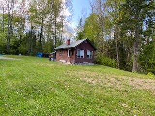254 Eaton Rd, Dexter, ME 04435 - view of side of home with a lawn and a chimney