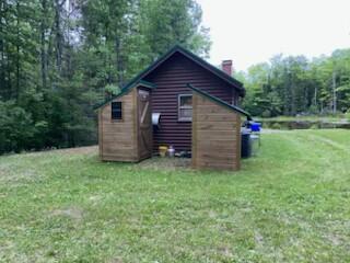 254 Eaton Rd, Dexter, ME 04435 - view of home's exterior with a chimney and a lawn