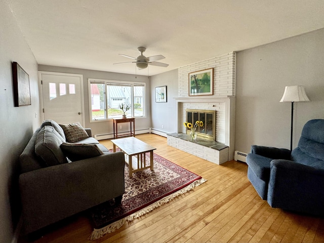 51 Francis St, Waterville, ME 04901 - living area featuring a baseboard heating unit, hardwood / wood-style floors, a ceiling fan, and a brick fireplace