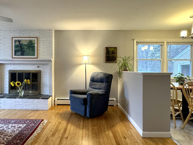 51 Francis St, Waterville, ME 04901 - living area featuring a baseboard heating unit, hardwood / wood-style floors, a baseboard radiator, baseboards, and a brick fireplace