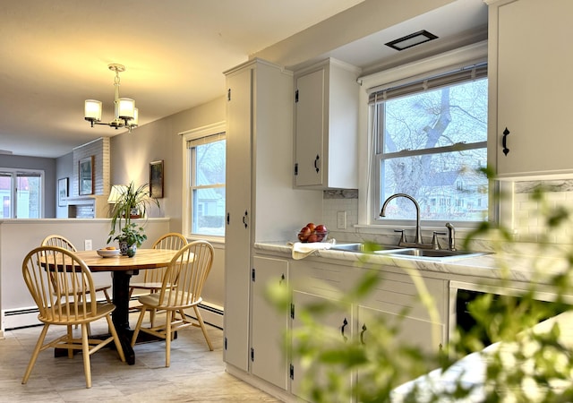 51 Francis St, Waterville, ME 04901 - kitchen with a sink, light countertops, backsplash, hanging light fixtures, and a chandelier
