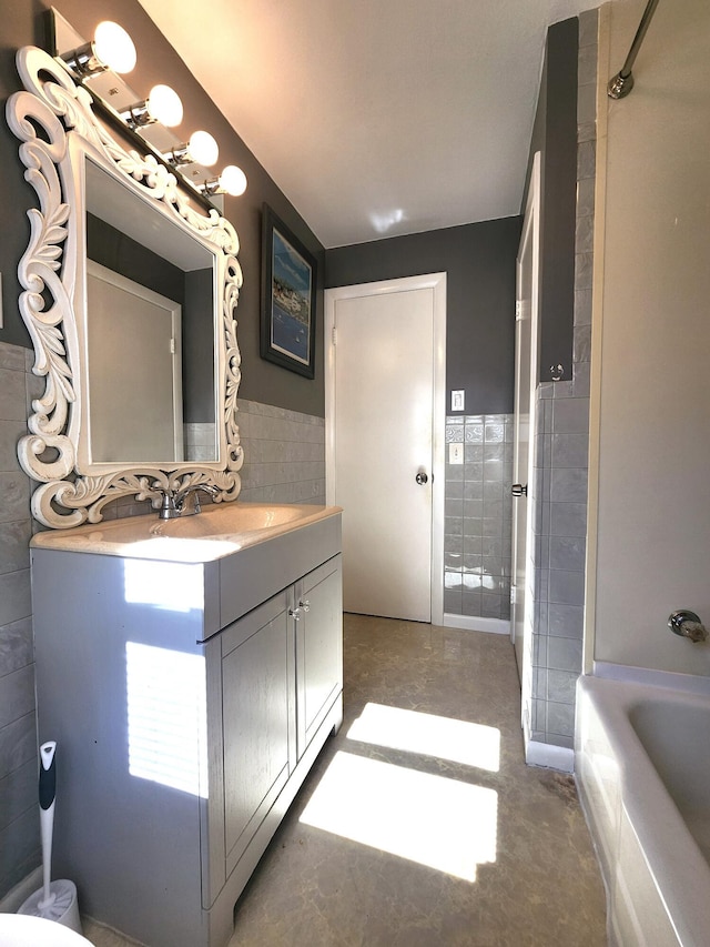 51 Francis St, Waterville, ME 04901 - full bathroom featuring tile walls, vanity, a tub to relax in, and a wainscoted wall