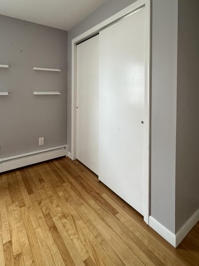 51 Francis St, Waterville, ME 04901 - unfurnished bedroom featuring a baseboard radiator, light wood finished floors, a closet, and baseboards
