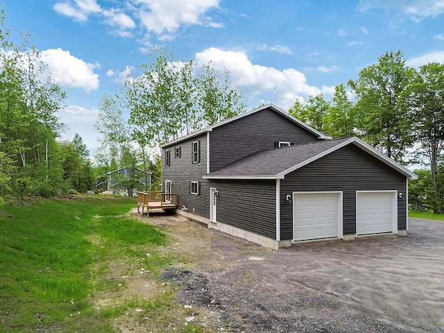65 May Way, Sidney, ME 04330 - view of side of property with a garage, asphalt driveway, a wooden deck, and a shingled roof